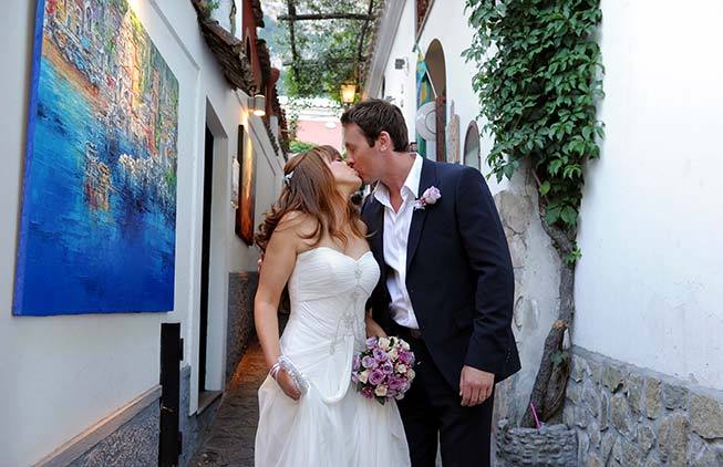 Romantic kiss of a newlywed couple in Positano