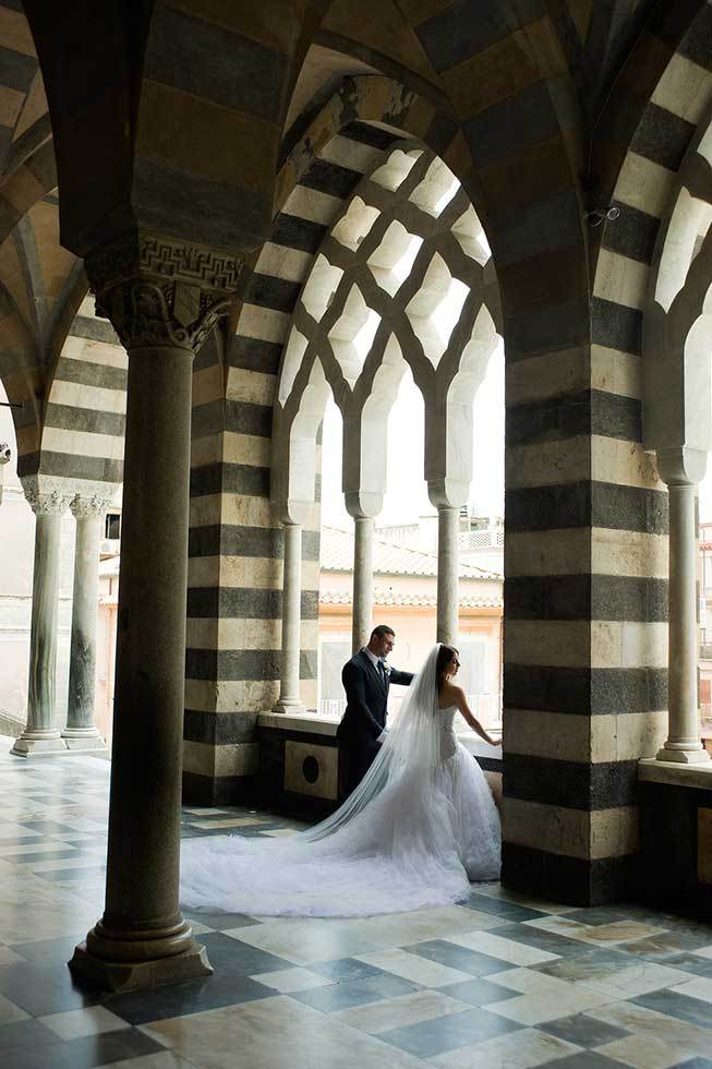Bride and groom under the arches of the Amalfi Duomo