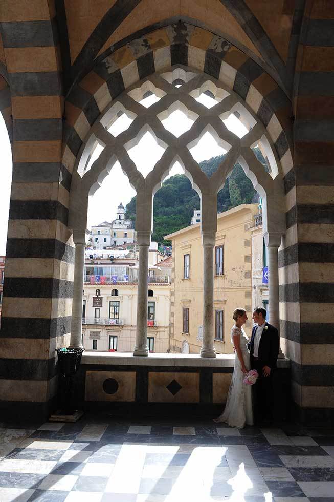 Bride and groom under the arches of Amalfi Duomo